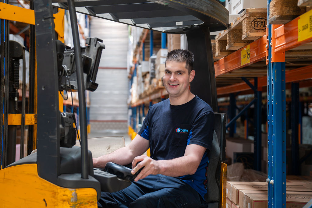 Collega met glimlach aan het werk in magazijn